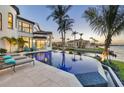 Backyard paradise with an infinity pool, lounge chairs, and views of the waterway at 641 Ranger Ln, Longboat Key, FL 34228