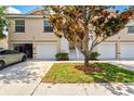 Charming front exterior with driveways, garages, an ornamental tree, and manicured lawn and shrubbery at 7039 Strand Cir # 34-201, Bradenton, FL 34203