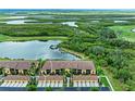 Scenic aerial view of townhomes overlooking a tranquil lake surrounded by lush greenery at 7315 River Hammock Dr # 101, Bradenton, FL 34212