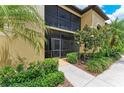 Inviting condo entrance with lush landscaping and covered balcony at 7315 River Hammock Dr # 101, Bradenton, FL 34212