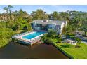 A relaxing pool surrounded by lounge chairs next to a pond offering residents a relaxing area at 754 Pine Run Dr # 754, Osprey, FL 34229