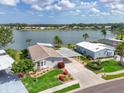 Beautiful waterfront property with well-maintained landscaping, blue siding, and covered parking at 8439 Imperial Cir, Palmetto, FL 34221