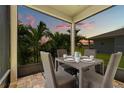 Covered patio seating area with wicker furniture and outdoor view at 11430 Gallatin Trl, Parrish, FL 34219