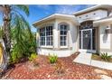 Close-up of the front exterior featuring arched windows, a decorative door, and low-maintenance landscaping at 1657 Bonita Bluff Ct, Ruskin, FL 33570