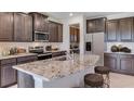 Modern kitchen showcasing granite countertops, stainless steel appliances, and dark wood cabinets at 18114 Metado Dr, Bradenton, FL 34211