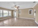 Bright living room with tiled floors, large windows, and a ceiling fan at 1830 Virginia Dr, Bradenton, FL 34205