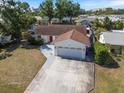 An elevated view of a home featuring a wide driveway, two-car garage, and surrounded by mature trees at 1856 Wharf Rd, Sarasota, FL 34231
