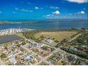 An aerial view showcases a home with a large body of water and a bright blue sky in the background at 2402 16Th W St, Palmetto, FL 34221