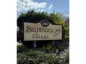 Community sign for Bayshore Village with mature landscaping and a conch shell decoration at 2808 60Th W Ave # 1924, Bradenton, FL 34207