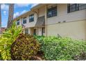Townhouse exterior featuring light siding, lush landscaping, and a view of the front entrance at 3610 54Th W St # B4, Bradenton, FL 34209