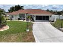 Charming single-story home with well-manicured lawn, decorative landscaping, and long driveway at 3984 Holin Ln, North Port, FL 34287