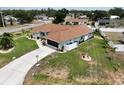 Aerial view of a well-maintained home with a long driveway, lush lawn, and fenced backyard at 3984 Holin Ln, North Port, FL 34287