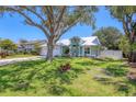 Charming single-Gathering home featuring a white metal roof, lush lawn and mature shade tree at 425 46Th Nw St, Bradenton, FL 34209