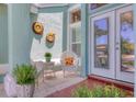 Cozy front patio area with wicker furniture and decorative sunflower wall decor and plant life at 425 46Th Nw St, Bradenton, FL 34209