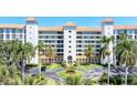 Beautiful condo building with manicured grounds, palm trees, and a circular driveway, showcasing luxury living at 4801 Osprey S Dr # 405, St Petersburg, FL 33711
