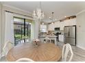 Cozy dining area with chandelier lighting adjacent to the kitchen and a sliding glass door at 5155 78Th St E Cir, Bradenton, FL 34203