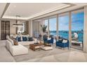 Bright living room with expansive windows showcasing the city and ocean views, plus modern furnishings at 555 Quay Cmn # 804, Sarasota, FL 34236