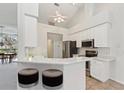 Bright, updated kitchen with white cabinets, stainless steel appliances and breakfast bar at 5596 Sabal Trace Dr, North Port, FL 34287