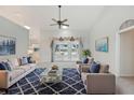 Bright living room featuring a plush rug, comfortable seating, and large windows with views of the lake at 5596 Sabal Trace Dr, North Port, FL 34287