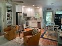 Bright kitchen featuring stainless steel appliances, white cabinets, and comfortable seating area with unique chairs at 590 Artists Ave, Englewood, FL 34223