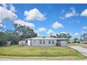 One-story home featuring a well-maintained lawn, mature trees, and covered parking at 5905 Olive Ave, Sarasota, FL 34231