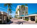 Exterior view showing covered parking and beach access lined with mature palms at 5966 Midnight Pass Rd # G-51 & G-58, Sarasota, FL 34242