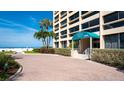 Attractive entrance to the condo building with beautiful landscaping and beach access at 5966 Midnight Pass Rd # G-51 & G-58, Sarasota, FL 34242