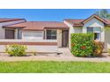 Inviting townhome entrance featuring a well-kept lawn and colorful hibiscus bushes at 6010 36Th Avenue W Cir # E, Bradenton, FL 34209