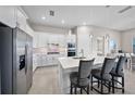 Modern kitchen with white cabinetry, stainless steel appliances, a large island, and stylish pendant lighting at 6244 Talon Preserve Dr, Nokomis, FL 34275