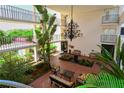 Open-air lobby features comfortable seating, a decorative chandelier, and lush landscaping, perfect for relaxation at 6285 Midnight Pass Rd # 403, Sarasota, FL 34242