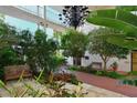 Beautifully landscaped entrance with lush greenery, benches, and a chandelier, creating a serene and welcoming atmosphere at 6285 Midnight Pass Rd # 403, Sarasota, FL 34242