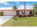 Charming single-story home with a well-manicured lawn, red shutters, and a side-entry two-car garage at 6615 12Th Ave W W Ave, Bradenton, FL 34209