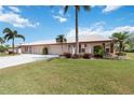 Spacious single-story home featuring a well-manicured lawn and a driveway leading to an attached garage at 6615 12Th Ave W W Ave, Bradenton, FL 34209