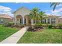 Inviting single-story home with lush landscaping, a well-manicured lawn, and charming covered entryway at 750 Anna Hope Ln, Osprey, FL 34229