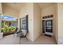 Welcoming front porch with seating area, and a view of the front door with sidelight, transom, and sidelight window at 750 Anna Hope Ln, Osprey, FL 34229