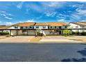 Two-story condos with covered parking, with well-maintained lawn and a palm tree at 1211 Capri Isles Blvd # 26, Venice, FL 34292