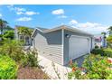 Attached two-car garage with a well-maintained driveway and lush landscaping at 1211 Spoonbill Landings Cir, Bradenton, FL 34209