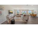 Bright living room with modern furniture, a large TV, and plenty of natural light at 13108 Bayberry Way, Parrish, FL 34219