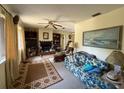 Comfortable living room with a ceiling fan, and fireplace with a large picture window at 13406 Leatherbury Ave, Port Charlotte, FL 33953