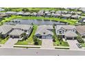 A high angle view of the home featuring a well maintained lawn, paver driveway, and lake views at 16905 Sweetwater Village Dr, Bradenton, FL 34211