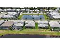 Aerial view of a neighborhood with a pond, showcasing many homes at 16905 Sweetwater Village Dr, Bradenton, FL 34211