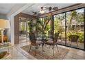 Bright dining area with glass walls, ceiling fans and stylish furniture, next to a garden view at 1703 Pelican Cove Rd # 356, Sarasota, FL 34231