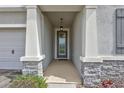Inviting front entryway with stone accents and a well-lit covered porch at 17032 Harvest Moon Way, Bradenton, FL 34211