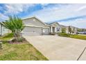 Charming single-story home with a three-car garage and neat landscaping under blue skies at 17032 Harvest Moon Way, Bradenton, FL 34211