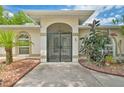 Close-up view of the home's entrance, showcasing the decorative front door and manicured landscaping at 2136 Bendway Dr, Port Charlotte, FL 33948