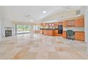 Spacious living area featuring tile floors, fireplace, and an open layout connecting to the kitchen and dining area at 2136 Bendway Dr, Port Charlotte, FL 33948