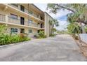 Multi-level condo with balconies, and lush landscaping; exterior view showcasing building architecture and tropical greenery at 2280 Stickney Point Rd # 420, Sarasota, FL 34231