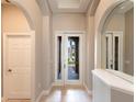 Bright foyer featuring arched doorways, tile flooring, and large mirrors creating an open and inviting space at 235 Dahlia Ct, Bradenton, FL 34212