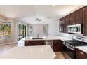 Modern kitchen with stainless steel appliances, white quartz countertops, island, and backyard pool views at 235 Dahlia Ct, Bradenton, FL 34212