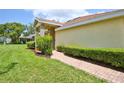 Inviting single-story home with a brick walkway, manicured hedges, and well-maintained lawn at 2407 New Haven Cir, Sun City Center, FL 33573